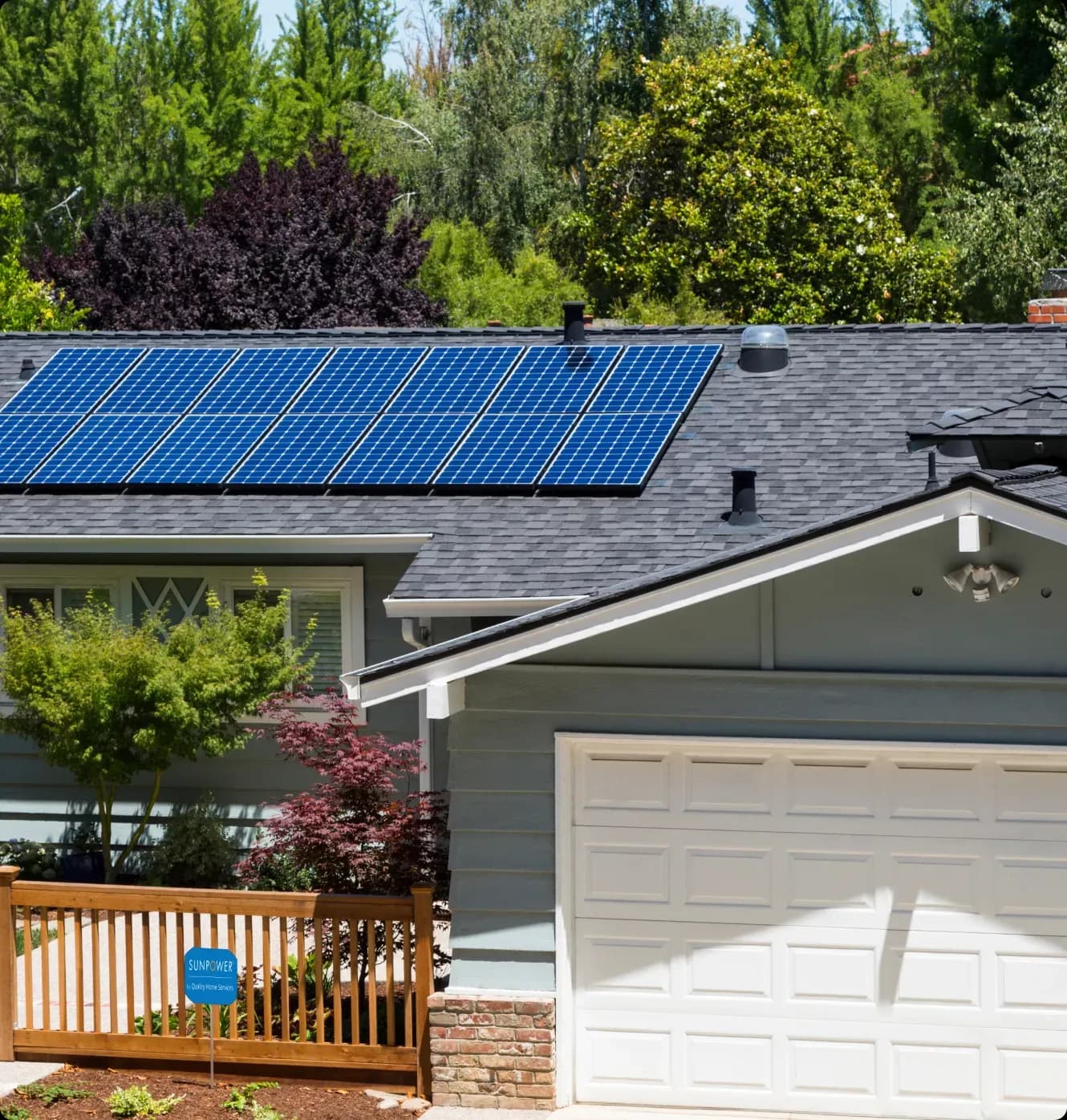 A suburban house with solar panels on the roof, surrounded by lush greenery. The scene conveys eco-friendliness and sustainability.